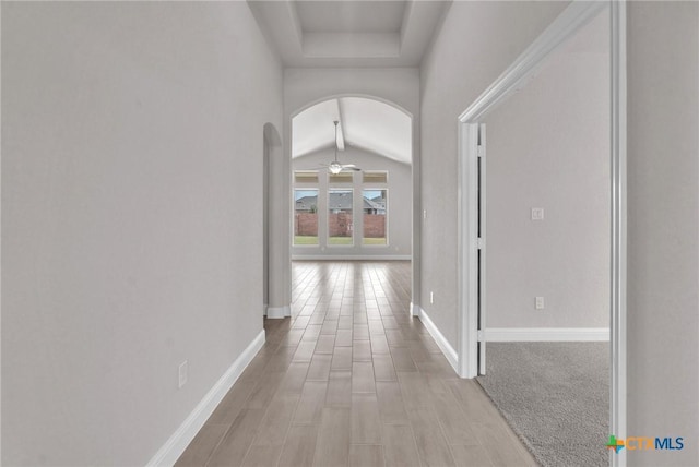 hallway with light hardwood / wood-style floors and lofted ceiling