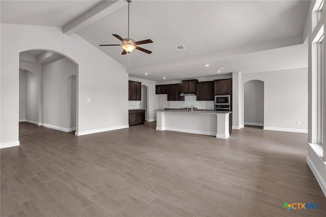 unfurnished living room with vaulted ceiling with beams, ceiling fan, sink, and hardwood / wood-style flooring