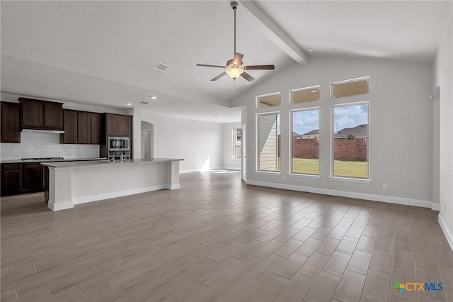 interior space featuring beamed ceiling, ceiling fan, light wood-type flooring, and high vaulted ceiling