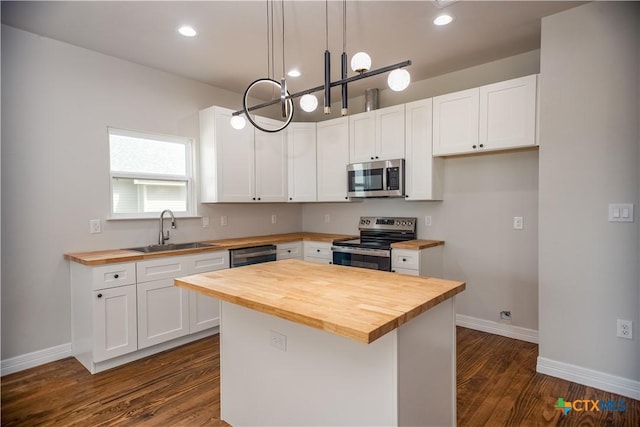 193 Powderhorn Ln, Port Lavaca, TX 77979 - kitchen with wooden counters, appliances with stainless steel finishes, dark wood-type flooring, white cabinets, and recessed lighting