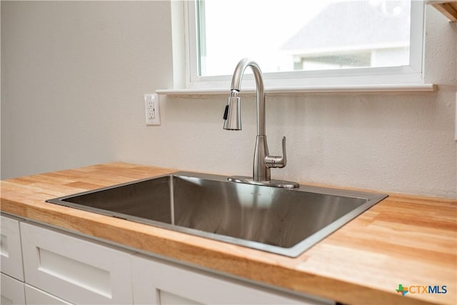 193 Powderhorn Ln, Port Lavaca, TX 77979 - kitchen view of white cabinetry, wood counters, and a textured wall