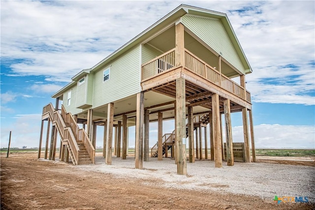 193 Powderhorn Ln, Port Lavaca, TX 77979 - rear view of house with stairs, a carport, and a deck