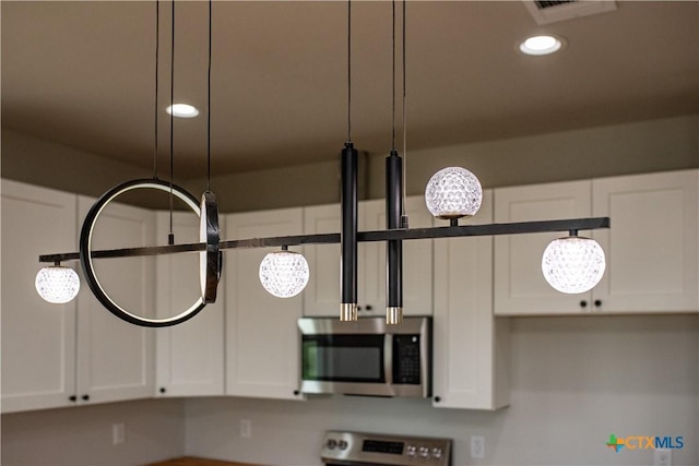 193 Powderhorn Ln, Port Lavaca, TX 77979 - kitchen view of stainless steel microwave, range, white cabinets, and recessed lighting