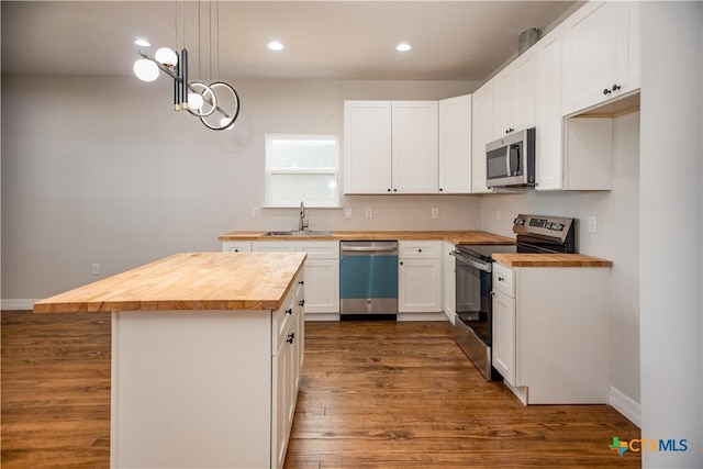 193 Powderhorn Ln, Port Lavaca, TX 77979 - kitchen featuring wooden counters, stainless steel appliances, white cabinetry, a kitchen island, and recessed lighting