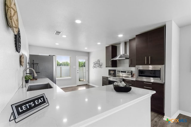 8606 Georgia Ave, Temple, TX 76502 - kitchen featuring a sink, light countertops, wall chimney exhaust hood, stainless steel appliances, and visible vents