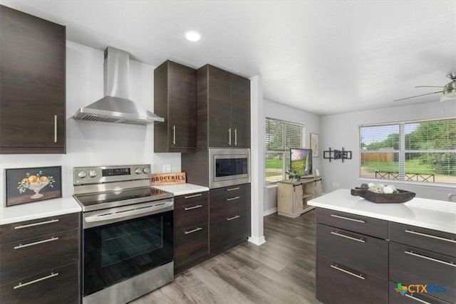 8606 Georgia Ave, Temple, TX 76502 - kitchen featuring light wood-type flooring, light countertops, wall chimney exhaust hood, and appliances with stainless steel finishes