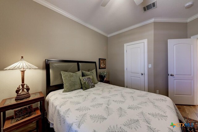 bedroom featuring hardwood / wood-style floors, ceiling fan, and ornamental molding