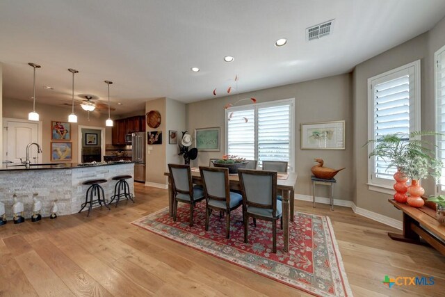 dining space featuring sink and light hardwood / wood-style floors