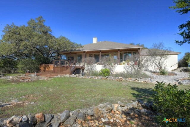 rear view of house featuring a yard and a wooden deck