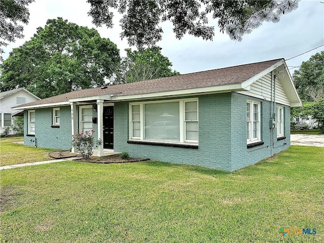 ranch-style house featuring brick siding and a front lawn