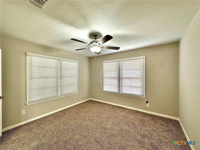 unfurnished room with carpet floors, a ceiling fan, a textured ceiling, and visible vents