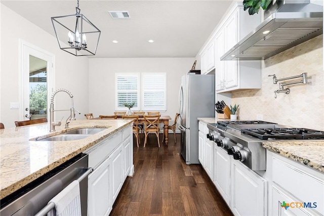 2618 Red Bud Way, New Braunfels, TX 78132 - kitchen featuring wall chimney range hood, stainless steel appliances, white cabinetry, light stone counters, and a chandelier