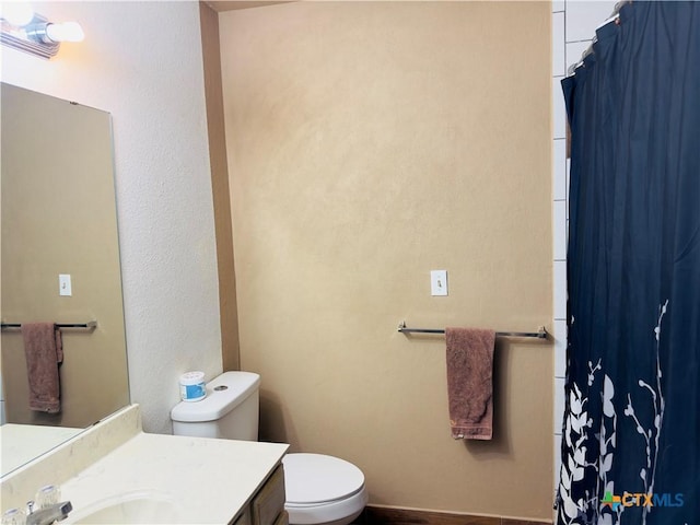 bathroom with vanity, curtained shower, and toilet