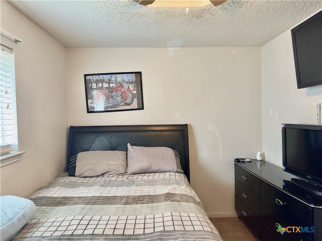 bedroom with ceiling fan, carpet flooring, and a textured ceiling