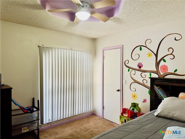 bedroom with ceiling fan, carpet, and a textured ceiling