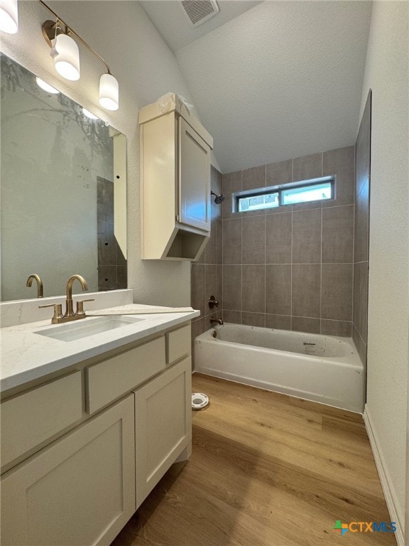 10818 Campsite Cv, Temple, TX 76502 - full bathroom featuring vanity,  shower combination, wood finished floors, and lofted ceiling