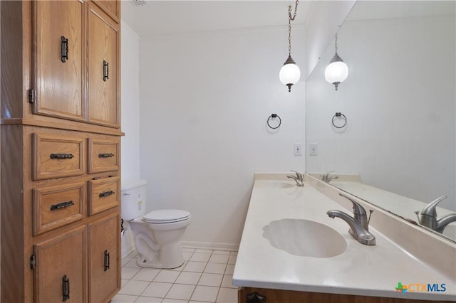 bathroom with a sink, tile patterned flooring, toilet, and double vanity