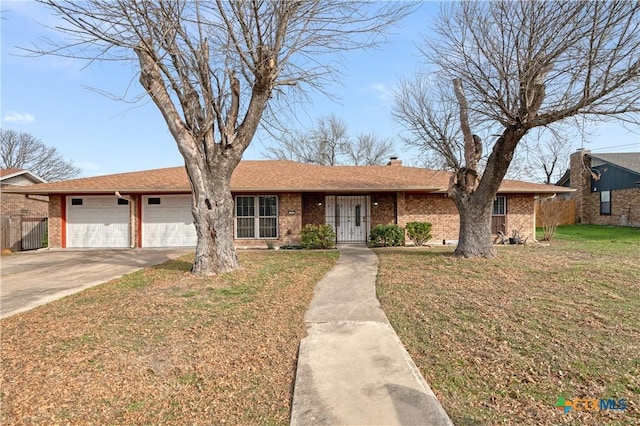 single story home with an attached garage, concrete driveway, a front yard, and brick siding