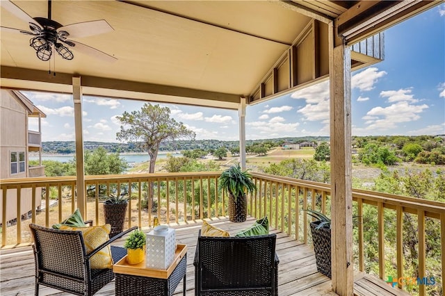 wooden terrace with ceiling fan, a water view, and an outdoor living space