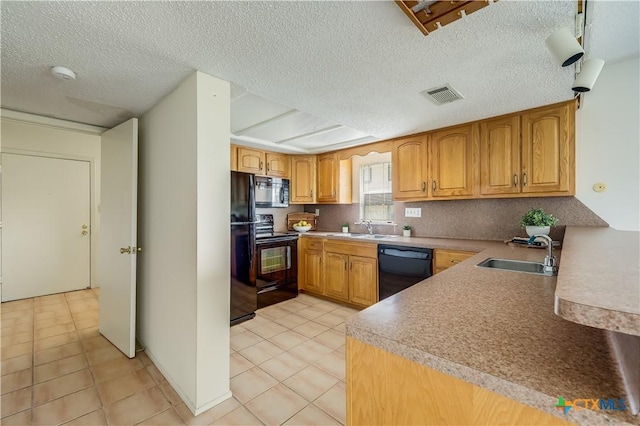 kitchen featuring light tile patterned floors, a textured ceiling, black appliances, and sink