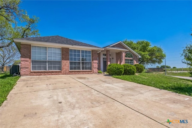 293 Reese Creek Rd, Killeen, TX 76549 - view of front facade with a shingled roof, a front yard, fence, and brick siding