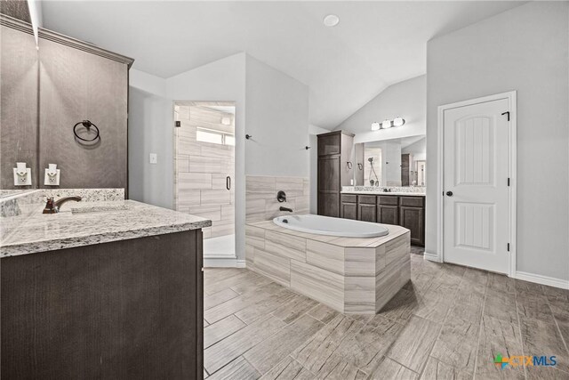 7511 Wind Chime Way, Temple, TX 76502 - bathroom featuring a garden tub, a shower stall, two vanities, wood finish floors, and vaulted ceiling