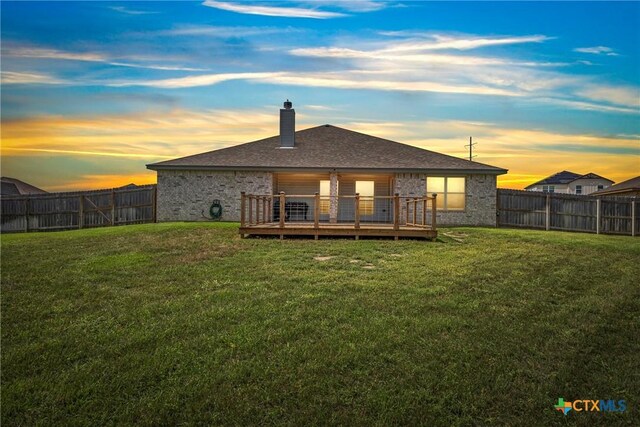 7511 Wind Chime Way, Temple, TX 76502 - back of property at dusk with a fenced backyard, a wooden deck, a chimney, and brick siding