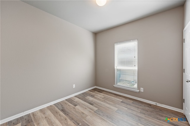 spare room with plenty of natural light and light hardwood / wood-style floors