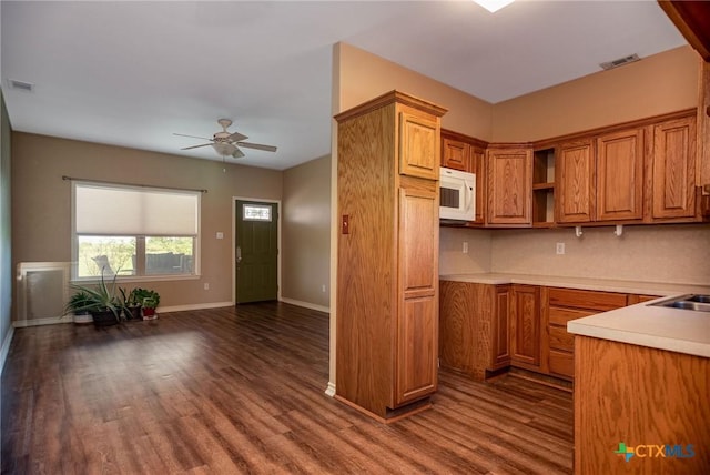 196 Garza Rd, Port Lavaca, TX 77979 - kitchen featuring white microwave, ceiling fan, brown cabinetry, and dark wood-style floors