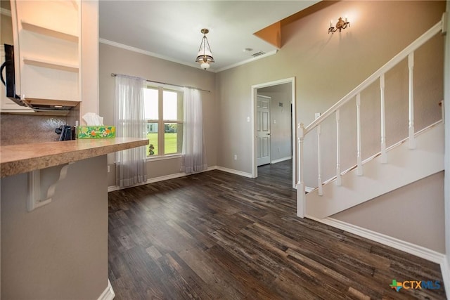 196 Garza Rd, Port Lavaca, TX 77979 - unfurnished dining area featuring dark wood-style floors, stairway, and ornamental molding
