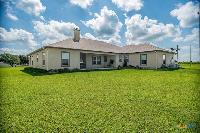 196 Garza Rd, Port Lavaca, TX 77979 - rear view of property with stucco siding, a chimney, and a lawn