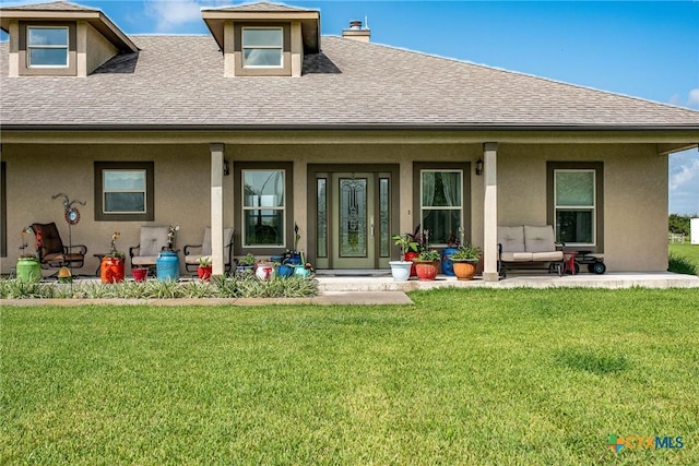 196 Garza Rd, Port Lavaca, TX 77979 - back of property with roof with shingles, covered porch, a lawn, and stucco siding