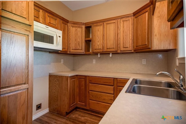 196 Garza Rd, Port Lavaca, TX 77979 - kitchen featuring white microwave, light countertops, dark wood-type flooring, and brown cabinets