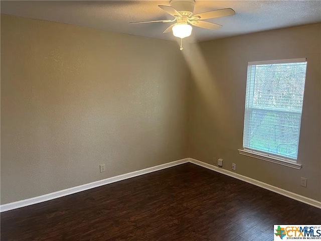 spare room with dark hardwood / wood-style floors and ceiling fan