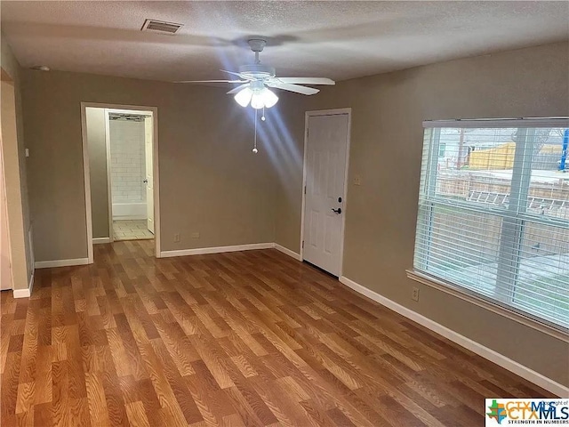 spare room featuring wood-type flooring, a textured ceiling, and ceiling fan