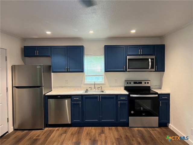 kitchen featuring crown molding, sink, blue cabinetry, appliances with stainless steel finishes, and dark hardwood / wood-style flooring