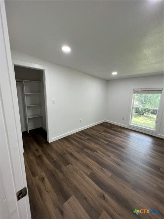 unfurnished bedroom featuring dark wood-type flooring and a closet