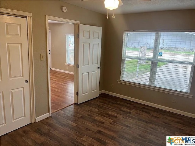 interior space with ceiling fan and dark wood-type flooring