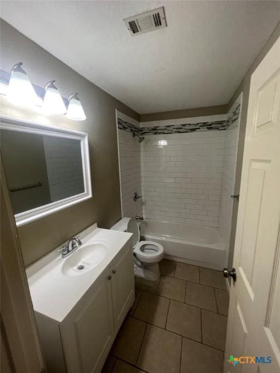 full bathroom featuring tile patterned flooring, vanity, toilet, and tiled shower / bath