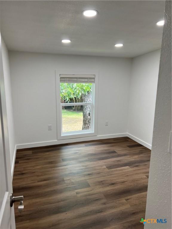 spare room with dark hardwood / wood-style flooring