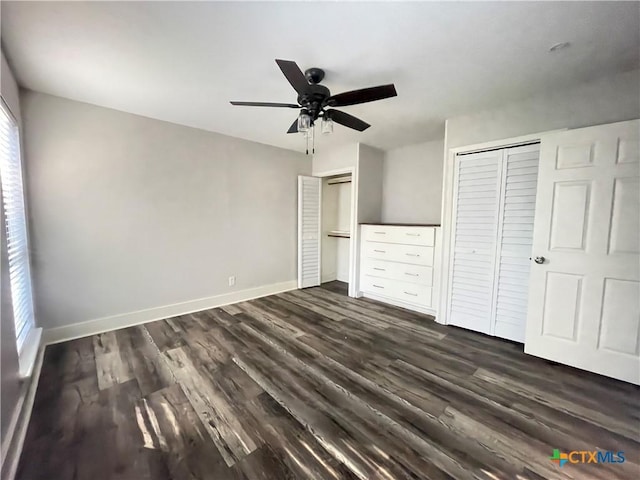 420 Londonderry Dr, Victoria, TX 77901 - unfurnished bedroom with two closets, dark wood-style floors, baseboards, and a ceiling fan