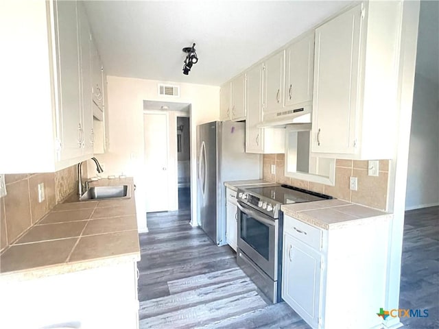 420 Londonderry Dr, Victoria, TX 77901 - kitchen featuring appliances with stainless steel finishes, a sink, under cabinet range hood, light wood-type flooring, and tile countertops