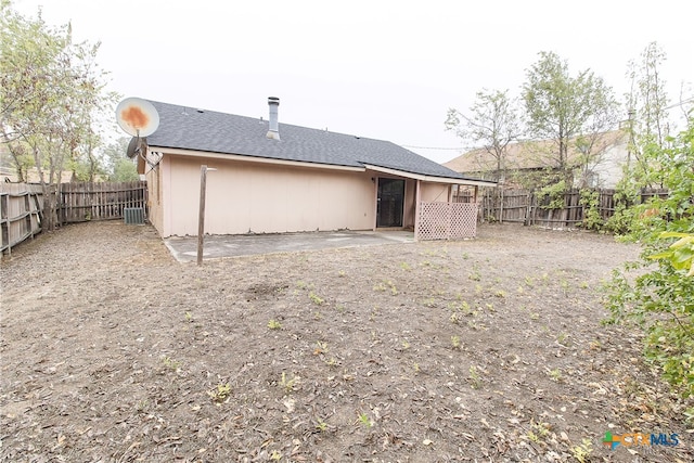 rear view of house with central air condition unit and a patio area