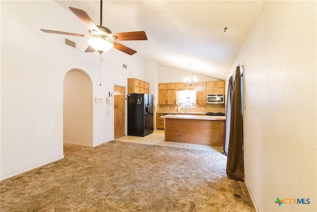 kitchen featuring light colored carpet, black fridge, pendant lighting, and kitchen peninsula