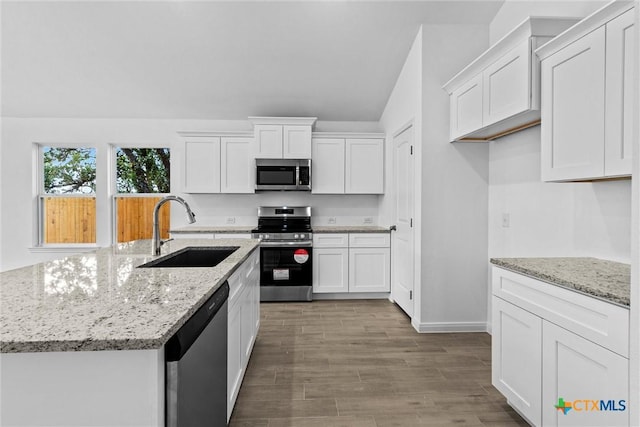 9820 Tarabon Dr, Killeen, TX 76542 - kitchen featuring appliances with stainless steel finishes, white cabinets, vaulted ceiling, and wood finished floors