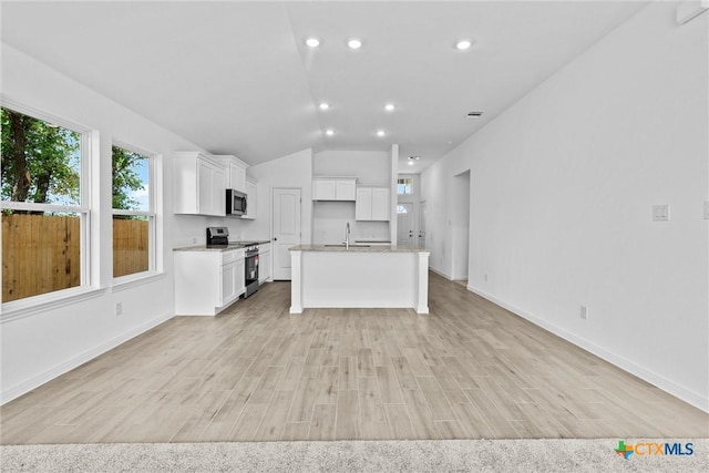 9820 Tarabon Dr, Killeen, TX 76542 - kitchen featuring appliances with stainless steel finishes, lofted ceiling, light wood-type flooring, white cabinets, and an island with sink