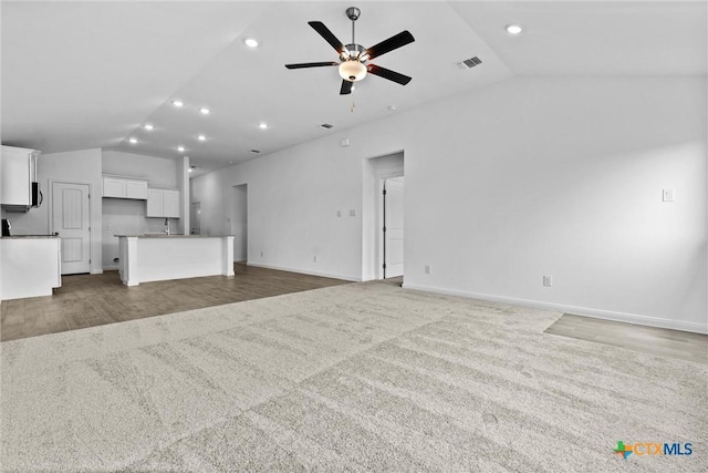 9820 Tarabon Dr, Killeen, TX 76542 - unfurnished living room with lofted ceiling, a ceiling fan, light colored carpet, recessed lighting, and light wood-style flooring