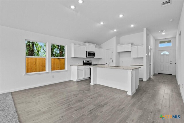9820 Tarabon Dr, Killeen, TX 76542 - kitchen featuring stainless steel appliances, a center island with sink, white cabinetry, light wood-style flooring, and open floor plan