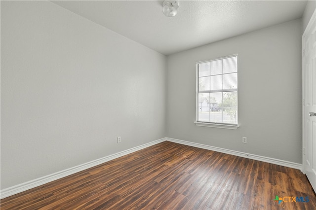 empty room with dark hardwood / wood-style flooring