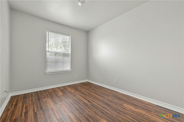 empty room with dark hardwood / wood-style flooring